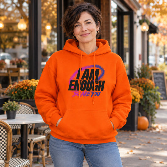 Orange I AM ENOUGH pullover hoodie with black lettering, lifestyle mockup